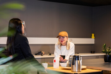 Women talking in office kitchen