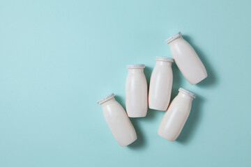 Bottles with probiotics and prebiotics dairy drink on light blue background.
