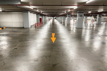 Yellow Arrow on the floor in empty underground parking lot.