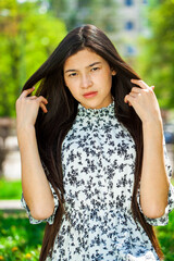 Portrait of a young beautiful girl in summer park