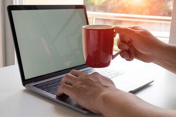 man using computer and have a cup of coffee
