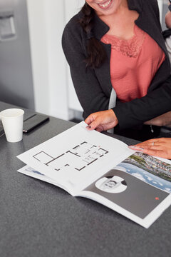Female estate agent showing house brochure