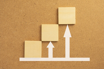 Wooden cube with white arrow up over wooden board background use for Business growth success concept with copyspace.