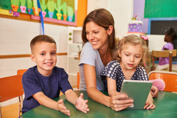 Kinder und Tagesmutter mit Ebook oder Tablet Computer - obrazy, fototapety, plakaty