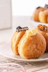 A bombolone or bomboloni is an Italian filled doughnut and is eaten as a snack food and dessert. This Bomboloni has many flavors like strawberry, chocolate, blueberry, etc.