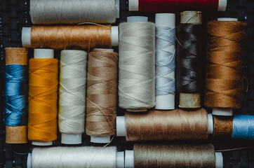 Retro sewing items: tailoring scissors, cutting knife, thimble, wooden thread spools, cushion for...
