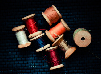 Retro sewing items: tailoring scissors, cutting knife, thimble, wooden thread spools, cushion for...