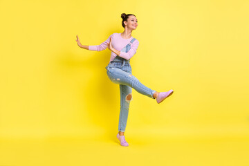 Fototapeta na wymiar Full length photo of cute charming young woman wear denim overall dancing isolated yellow color background
