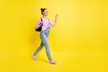 Fototapeta na wymiar Full size profile photo of optimistic nice brunet lady go wave hand wear overall isolated on yellow background