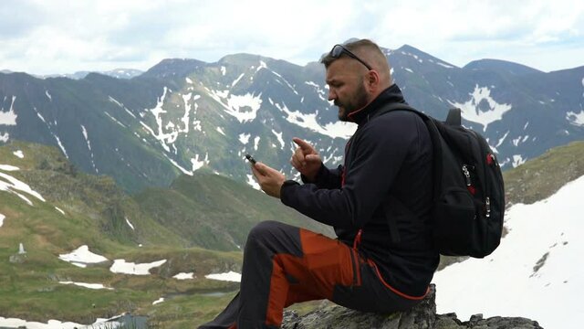 Young man checking map on smartphone in the mountains