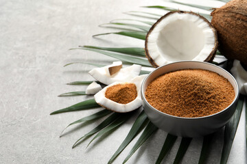 Composition with natural coconut sugar on grey table, space for text