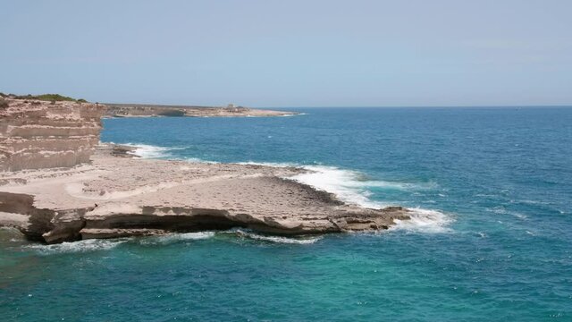 View of ocean waves splash against rocks background, Malta coast. Shot in 4k. Wave crushing coast Ocean. Beautiful Wave seafoam. Awesome power of waves breaking over dangerous rocks cliff