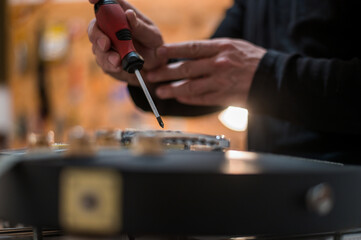 Black electrical guitar in repair service shop with a hands of a guitar luthier
