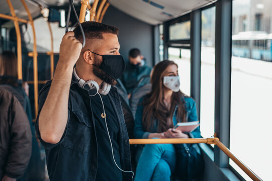 Young man wearing protective mask while riding a bus