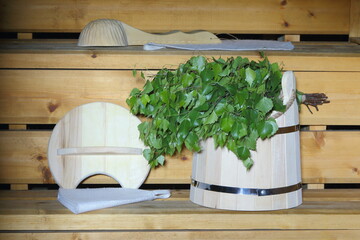Accessories for sauna and bath treatments and fresh birch broom in an interior of the bathhouse. 
