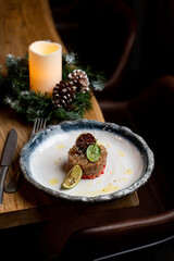 Fototapeta na wymiar Fine dining fish tartar with lemon juice on a beautiful stone dish, side view