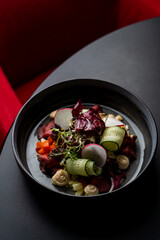 Top view of scandinavian beef steak salad, with mustard sauce, peas and cucumber, black flat background