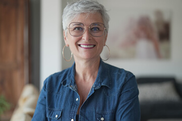 portrait of a 55 year old smiling senior woman in her home