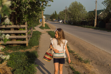 girl with basket walking in countryside on sunlight, russian village colour