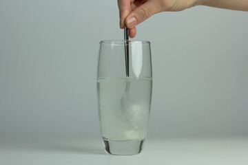 Closeup of myo-inositol powder dissolved in a glass of water.