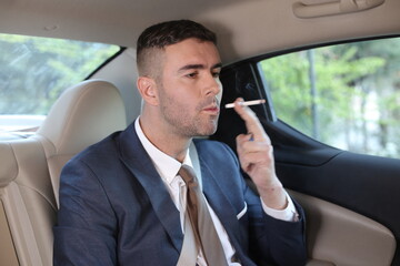 Careless businessman smoking in backseat 