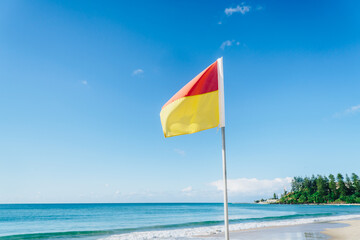 Lifeguard flag on Coolangatta beach with Greenmount headland view