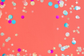 Bright and colorful confetti frame on pink background
