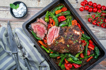 Traditional Greek barbecue lamb roast with vegetable and tzatziki offered as top view in a rustic...