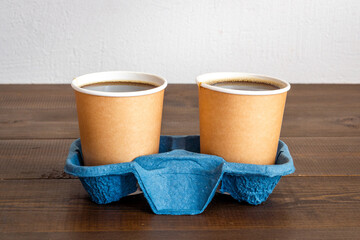 Take away coffee in paper cups on wooden desk