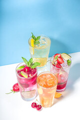 Iced refreshing drink. Bar and caffee beverage menu background. Set of various cold summer cocktails - peach tea, lemonade, mojito, cherry mocktail, with frruits on colorful bright blue background