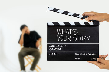 what's your story.title text on film slate and stressed man on a chair