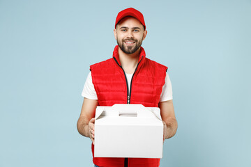 Delivery guy employee man in red cap white T-shirt vest uniform workwear work as dealer courier hold cake dessert in unmarked blank box isolated on pastel blue color background studio Service concept