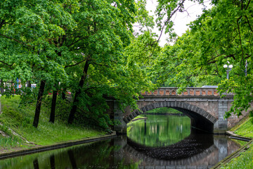 old stone bridge over the canal in the park, urban background with copy space