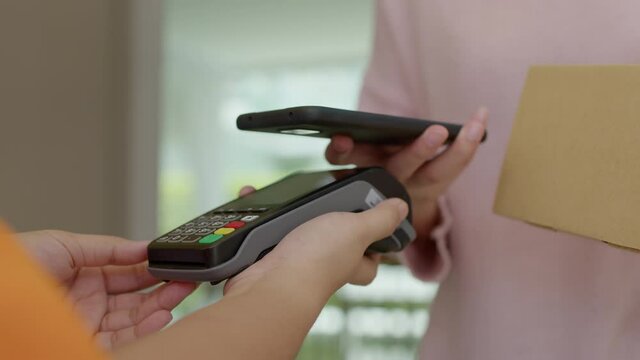Asia young smile happy woman people receive parcel postal from e-commerce online shop store use tapping cashless wifi qr code nfc bill scan app smart pos device reader in city life home contactless.