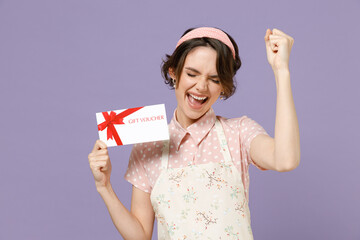Fun happy young housewife housekeeper chef cook baker woman in pink apron holding gift voucher...
