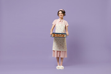 Full length young happy housewife housekeeper chef cook baker woman wearing pink apron show...
