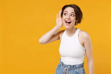 Young curious nosy caucasian woman 20s with bob haircut wearing white tank top shirt try to hear...