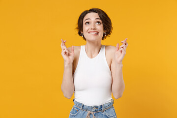 Young woman 20s with bob haircut wearing white tank top shirt waiting for special moment, keeping...