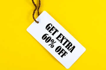 GET EXTRA 60 OFF percent text on a white tag on a yellow paper background