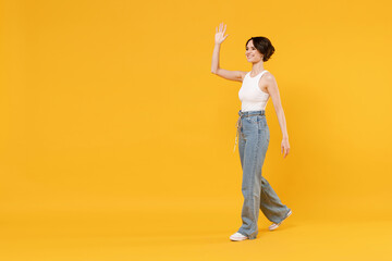 Full length side view young smiling happy woman 20s with bob haircut wearing white tank top shirt...