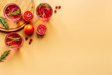 Fototapeta premium Glasses of cranberry lemonade and red oranges with rosemary