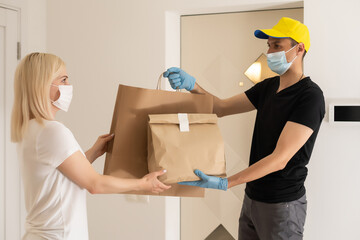 The shipper wears a mask and gloves, delivery food to the home of the online buyer. stay at home...