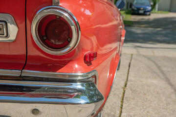 Antique 1963 red convertible closeup of the rear tail light and bumper.