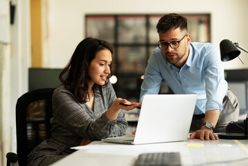 Obraz premium Colleagues in office. Businesswoman and businessman discussing work in office.