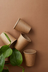 Zero waste. disposable paper cups with green leaves. Coffee and ecology. Beige background