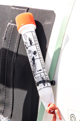 a ripcord for opening a lifeboat on a ferry. 
a white and red plastic cover with a functional...