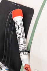 a ripcord for opening a lifeboat on a ferry.  a white and red plastic cover with a functional...