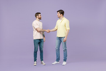 Full length two young smiling happy men friends together in casual t-shirt meeting together greet...