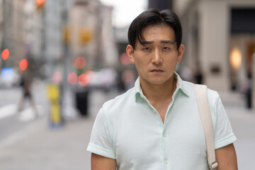 Young Asian man in city serious face portrait