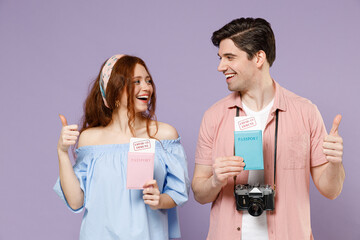 Two traveler tourist woman man in shirt hold passport covid19 immune vaccination board pass ticket show like isolated on purple background. Passenger travel abroad weekend getaway Air flight concept